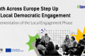 The visuals shows the text: “Youth Across Europe Step Up for Local Democratic Engagement” and the subtitle “Implementation of the Local Engagement Phase.” The image shows a black-and-white photo of a diverse group of young people sitting in a circle and participating in a group discussion. Colorful graphic shapes appear around the photo. Logos of ESN and the European Union are displayed at the bottom, along with the hashtag #SpeakOut.